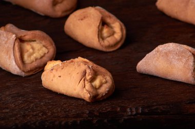 Ev yapımı çörekler ahşap arka plan üzerinde süzme peynir ile doldurulmuş. Seçici odak.