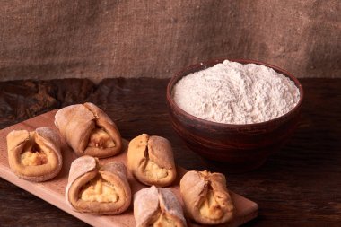 un, kil kase ürünlerinde cheesecakes Ahşap Doğrama tahtası üzerinde yapmak için. Siyah arka plan üzerine ev yapımı peynir kurabiye