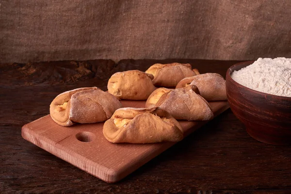 Kil kase un, oklava ve süzme peynir kurabiye ile. Cookie koyu arka plan üzerinde pişirme.