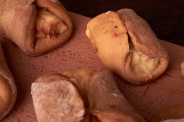 Ev yapımı çörekler ahşap arka plan üzerinde süzme peynir ile doldurulmuş. Seçici odak.