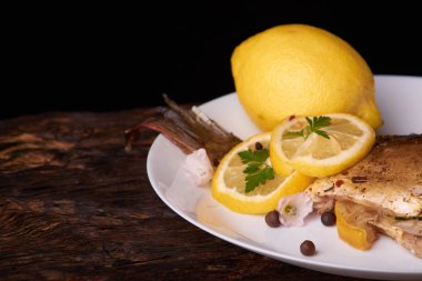 limon dilimleri, baharat ve fırın tepsisine, taze biberiye ile lezzetli kavrulmuş sazan balık yukarıdan görüntülemek