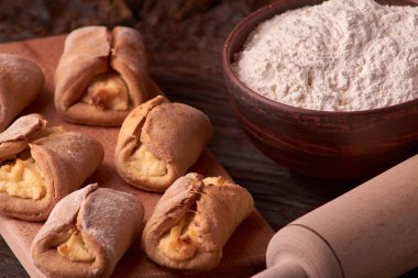 un, kil kase ürünlerinde cheesecakes Ahşap Doğrama tahtası üzerinde yapmak için. Siyah arka plan üzerine ev yapımı peynir kurabiye