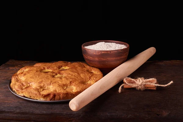 Siyah ahşap bir zemin üzerine un ve kayısı kek ile bir kase