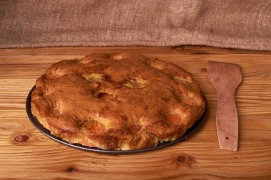 koyu ahşap arka plan üzerinde ahşap bir kürek ile kayısı kek