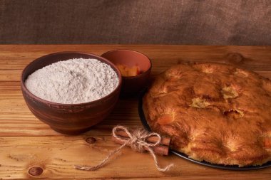 Koyu ahşap bir masa, moda fırın, un ile bir kase, masaya stand kayısı kek ve araçları