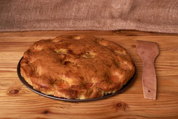 koyu ahşap arka plan üzerinde ahşap bir kürek ile kayısı kek