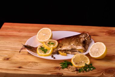 limon dilimleri, baharat ve beyaz tabak, yukarıdan görünüm, yakın çekim taze biberiye ile lezzetli kavrulmuş sazan balık