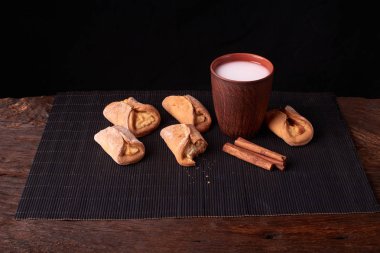 Süzme peynir ve ahşap masa arka plan üzerinde süt ile tatlılar. Resepsiyon mini pies. Rustik tarzı.