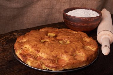 kayısı pasta ve bir kase un ve diğer malzemeler ahşap tablo