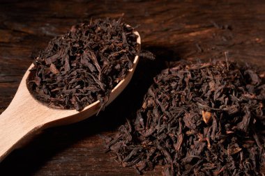 Güzel bir siyah arka plan üzerine bir tahta kaşık çay.