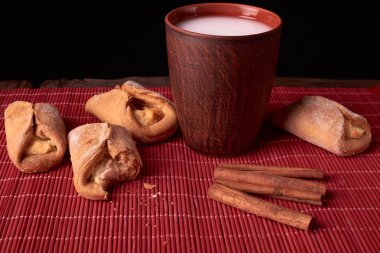 Süzme peynir kurabiye parçaya nibbled. allık cam ahşap masa üzerinde süt pişirme ve kil. tatlı ve lezzetli kurabiye