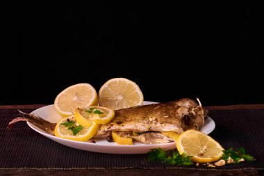 Otlar ve ahşap zemin, üstten görünüm üzerine limon ile ızgara balık. Akdeniz lüks deniz ürünleri kavramı