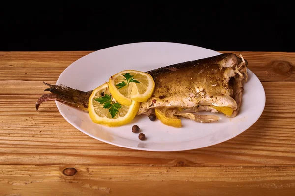 limon dilimleri, baharat ve fırın tepsisine, taze biberiye ile lezzetli kavrulmuş sazan balık yukarıdan görüntülemek