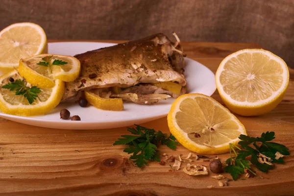 limon dilimleri, baharat ve fırın tepsisine, taze biberiye ile lezzetli kavrulmuş sazan balık yukarıdan görüntülemek