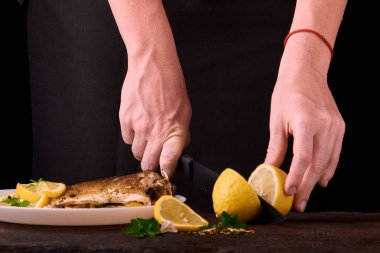 Tanınmayan kadın kesme taze limon yemek mutfakta, eller yakın çekim görünümünü için ahşap tahta üzerinde