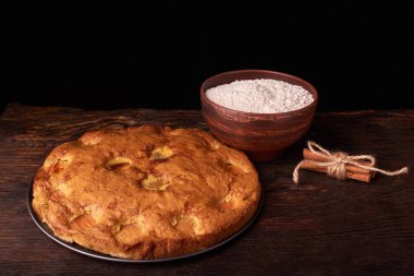 kayısı pasta ve bir kase un ve diğer malzemeler ahşap tablo