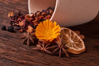 krem Kupası ve rustik ahşap masa arka plan üzerinde çay, meyve ve kuru meyve çay yaprakları