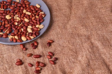 Fried kavrulmuş fıstık tohum çul zemin üzerine mavi plaka üzerinde