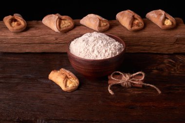 un, kil kase ürünlerinde cheesecakes Ahşap Doğrama tahtası üzerinde yapmak için. Siyah arka plan üzerine ev yapımı peynir kurabiye