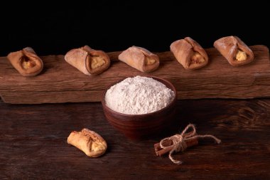 Kil kase un, oklava ve süzme peynir kurabiye ile. Cookie koyu arka plan üzerinde pişirme.