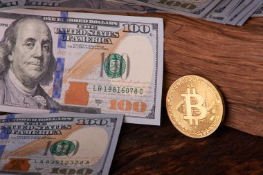 Güzel gri bir arka plan üzerinde faturaları 100 dolar ve altın sikke bitcoin düzenlenmiş. Bitcoin cryptocurrency. Anonim