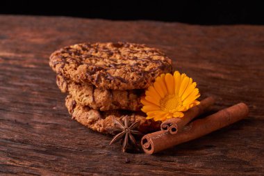 ahşap masa çikolata şurubu çerezleri sulanır. Çiçek ve tarçın sopa ile şirin kompozisyon