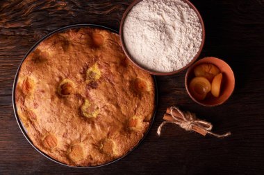 kayısı pasta ve bir kase un ve diğer malzemeler ahşap tablo