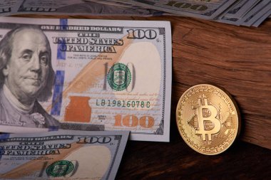 Güzel gri bir arka plan üzerinde faturaları 100 dolar ve altın sikke bitcoin düzenlenmiş. Bitcoin cryptocurrency. Anonim