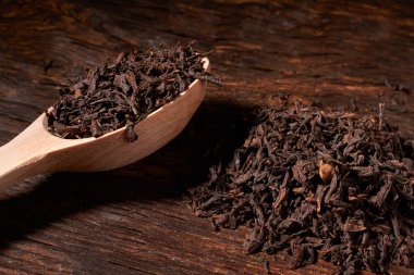 Güzel bir siyah arka plan üzerine bir tahta kaşık çay.