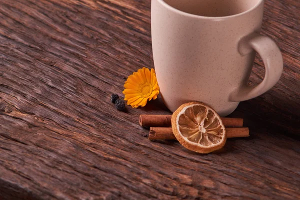 Dried fruit tea for healthy breakfast. cup of cream color and flower on wooden table