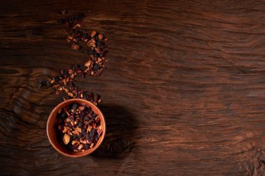 Kupası ve ahşap bir masaya izole kuru çay yaprakları