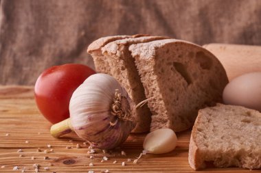 taze ekmek lezzetli pişirme için kavram. Kil kase, garlik, domates ve buğday filizi ahşap masa üzerinde yumurta