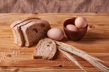 taze ekmek lezzetli pişirme için kavram. Ahşap masa kil kase yumurta