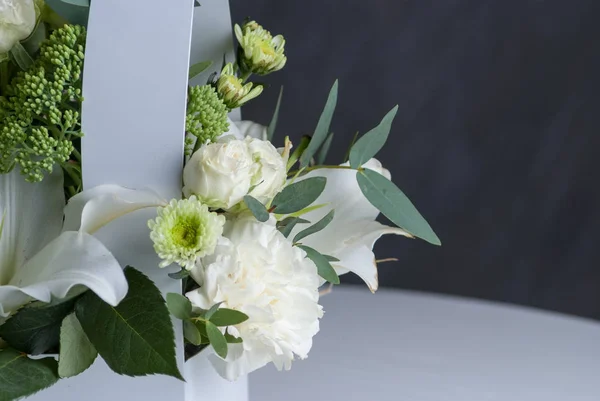 Vita rosor i vit pappkartong på bord och grå bakgrund. Närbild — Stockfoto