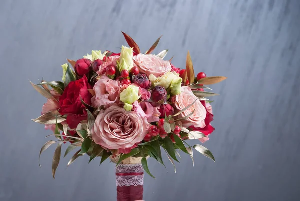 Red bouquet of red roses. Wedding flowers on gray background