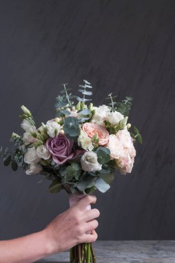 Gri arka plan üzerinde şeftali ve pembe gül buketi