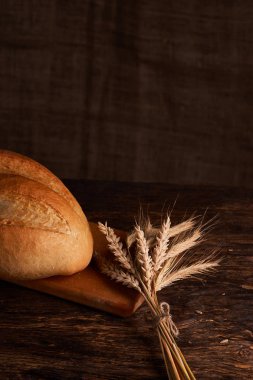 Fırın ekmek üreticileri - altın rustik huysuz somun ekmek ve siyah kara tahta zemin üzerine buns