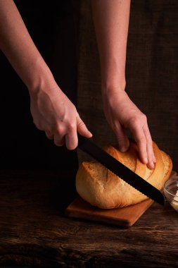 koyu ahşap mutfak masasında taze pişmiş ekmek