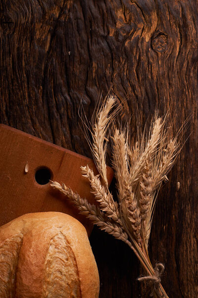 Вид сверху цельного хлеба на темном деревянном фоне
