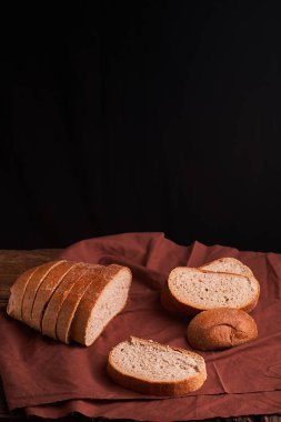 koyu ahşap masa ve kahverengi peçete üzerinde ekmek. Ekmek dilimleri ve yukarıdan izlendi kırıntıları.