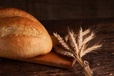 Fırın ekmek üreticileri - altın rustik huysuz somun ekmek ve siyah kara tahta zemin üzerine buns