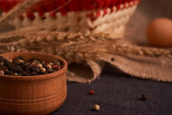 Peppercorns en un tazón de madera en la mesa con comida de estilo rústico. Comida casera —  Fotos de Stock