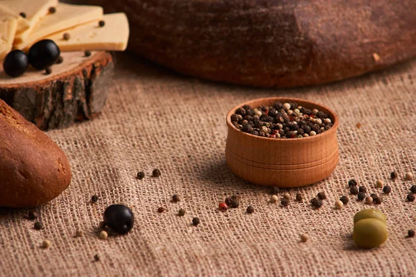 Peppercorns en un tazón de madera en la mesa con comida de estilo rústico. Comida casera —  Fotos de Stock