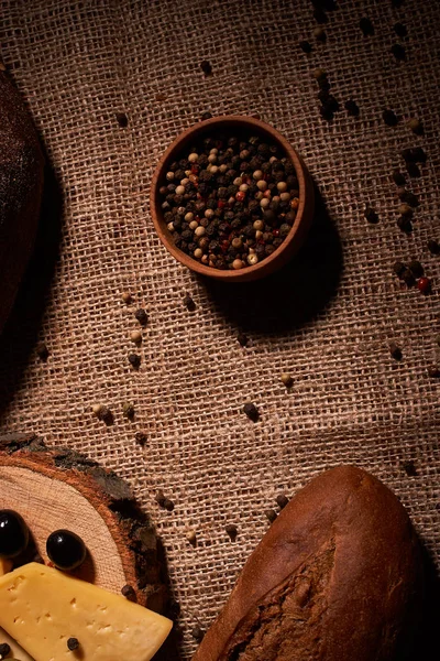 Rebanadas de queso en el escritorio de madera entre diferentes panes. lugar para el texto — Foto de Stock