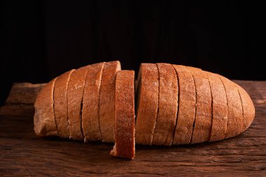 Fırın ekmek üreticileri - altın rustik huysuz somun ekmek ve siyah kara tahta zemin üzerine buns. Natürmort yukarıdan yakalanan