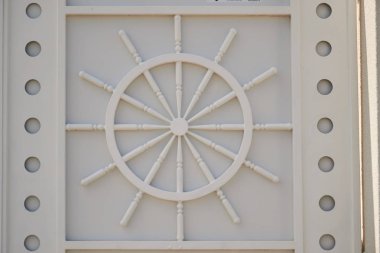 Bir savaş arabası tekerlek beyaz duvara oyulmuş. duvarda heykel