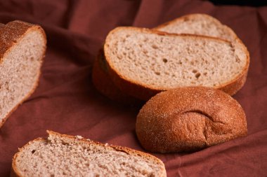 Fırın ekmek üreticileri - altın rustik huysuz somun ekmek ve siyah kara tahta zemin üzerine buns. Natürmort yukarıdan yakalanan