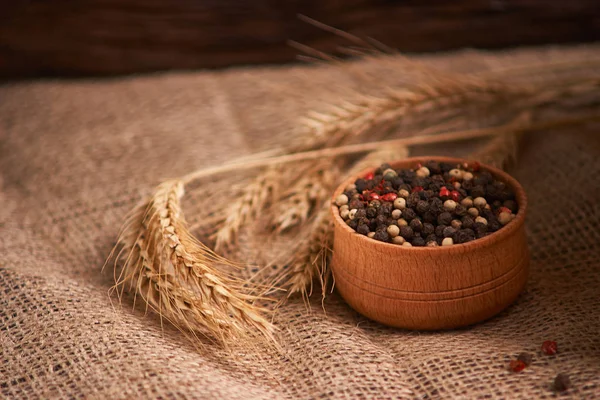 Peppercorns en un tazón de madera en la mesa con comida de estilo rústico. Comida casera —  Fotos de Stock