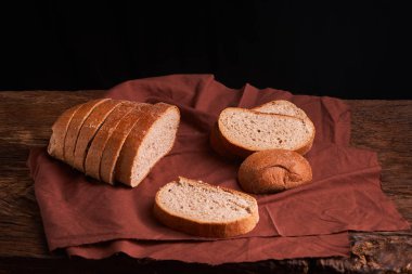 Fırın ekmek üreticileri - altın rustik huysuz somun ekmek ve siyah kara tahta zemin üzerine buns. Natürmort yukarıdan yakalanan