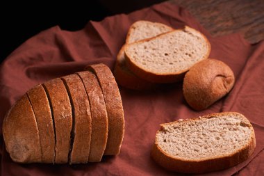 Fırın ekmek üreticileri - altın rustik huysuz somun ekmek ve siyah kara tahta zemin üzerine buns. Natürmort yukarıdan yakalanan